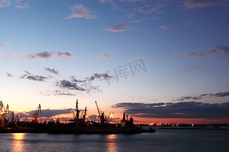 “港口中几只起重机的剪影，在日落时拍摄”