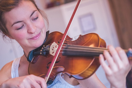 练习古典音乐和小提琴概念：小女孩愉快地拉小提琴