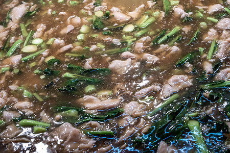锅里的面条摄影照片_锅里有猪肉和西兰花的炒面的特写镜头。