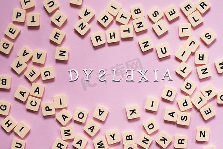 粉红色背景中心带有 DYSLEXIA 字的字母拼块