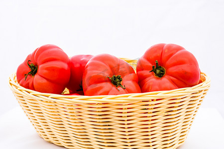 柳条篮中新鲜可口的红番茄被隔离