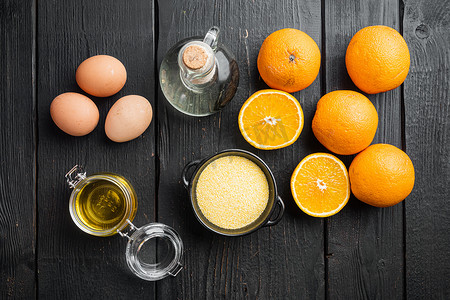 波伦摄影照片_黑色木桌背景上的橙色波伦塔蛋糕配料，配鸡蛋和蜂蜜，顶视图平躺