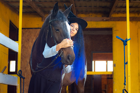 一个打扮成女巫的女孩抱着一匹马，若有所思地望着远方