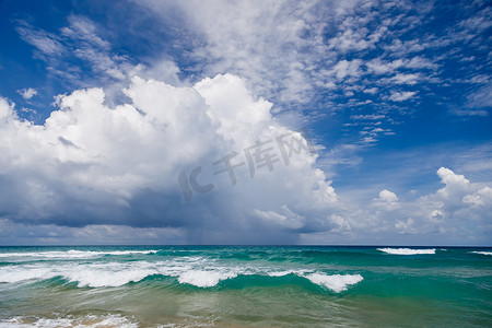 海景，与白色泡沫的波浪在蓝色水的背景下在上面。