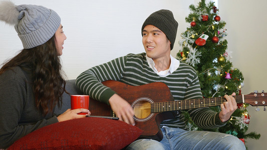 男人和女人坐在沙发上弹吉他唱歌