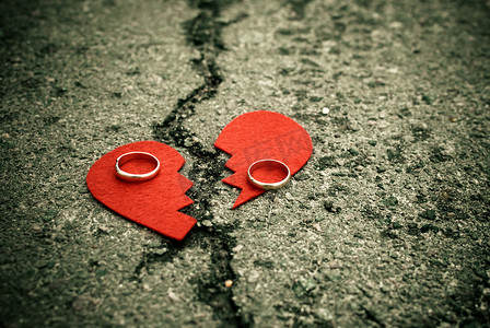 碎裂的沥青上带着结婚戒指的心碎 — 离婚概念 —