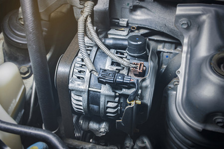 苯并摄影照片_汽油发动机中的汽车交流发电机、汽车发动机充电系统的组件、汽车零件概念