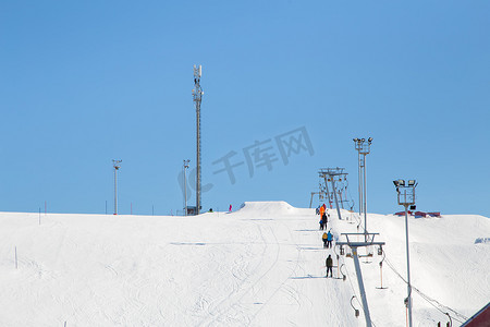 滑雪胜地，平缓的雪坡，人们乘坐电梯前往山顶。