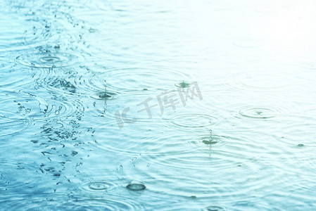 雨滴在水面上形成同心圆和水滴