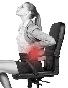 女性腰痛摄影照片_腰痛的女商人坐在办公椅上