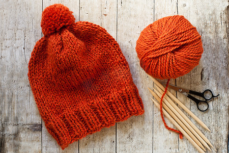 羊毛橙色帽子、织针和毛线
