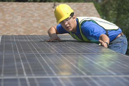 维修工人测量加利福尼亚州洛杉矶屋顶的太阳能电池阵列