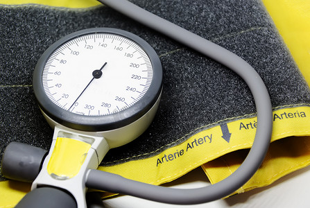 一种便携式血压计，固定在黄色袖口上，适合成年人使用魔术贴封口。