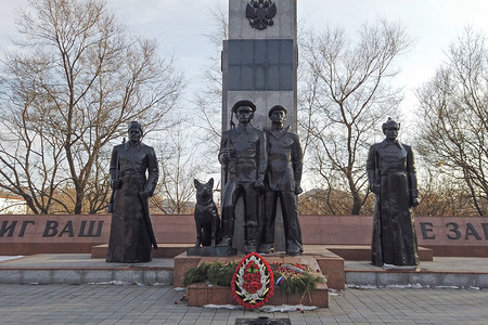 背景纪念碑摄影照片_以城市为背景，由石头和青铜制成的边防卫士纪念碑。