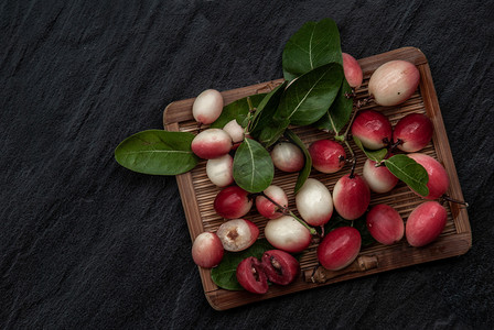 plum摄影照片_Bengal-Currants、Carandas-plum 或 Karonda 水果 (Carissa carandas L.) 柳条上的酸味水果。