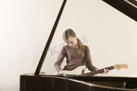 钢琴吉他摄影照片_弹吉他的女孩（13-15 岁）