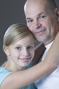 肩部环绕摄影照片_女儿拥抱父亲的工作室肖像