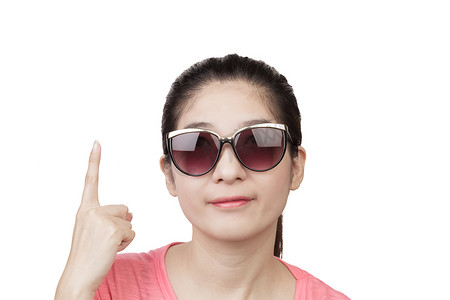数摄影照片_亚洲女人微笑着，戴着眼镜，指着白色