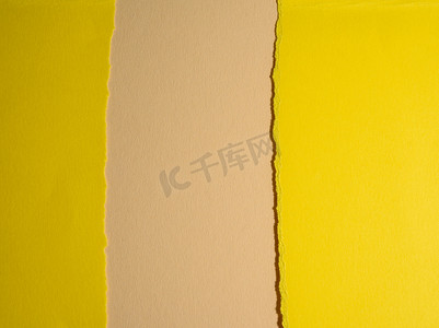 黄色页面摄影照片_米色背景上黄色纸板撕裂的边缘，带阴影的抽象背景