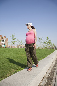 粉红色孕妇摄影照片_粉红色孕妇在公园散步