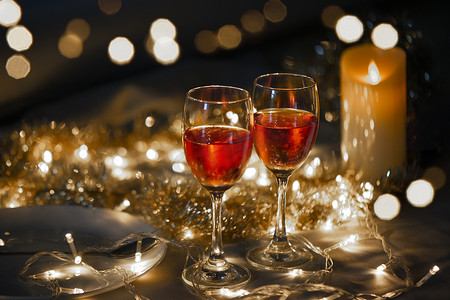小红书褐色摄影照片_小金光背景上两个红酒杯的庆典主题