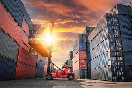 码头货运摄影照片_进出口货运行业的集装箱船装载，运输起重机叉车在港口货运码头堆场提升箱式集装箱。