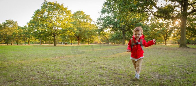 阳光明媚的夜晚，可爱的小男孩在公园里奔跑