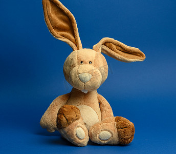 有趣的米色毛绒兔子，长着大耳朵和滑稽的脸