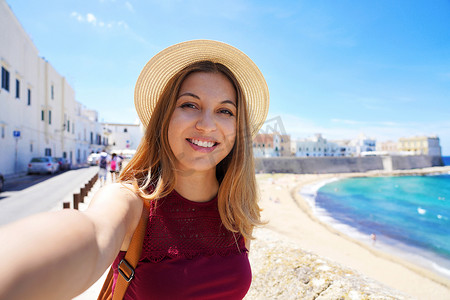 快乐的年轻女人用智能手机自拍，捕捉暑假旅行的瞬间