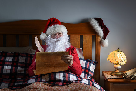 圣诞老人坐在他的床上，处理他顽皮而漂亮的清单。