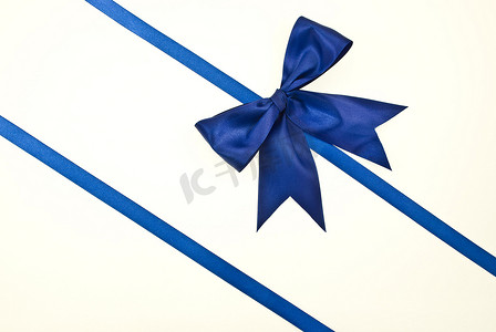 蓝元素摄影照片_带蓝丝带和蝴蝶结的礼品包装，与白色隔离