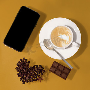 一杯加巧克力的咖啡，心形豆，桌上的电话