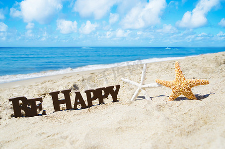 在沙滩上签名“Be Happy”和两只海星