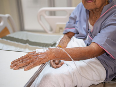 在医院里，生理盐水滴在老妇人的手上。