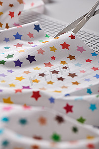 用剪刀在工艺垫上加工带有彩色星星图案的织物