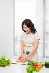 厨房切菜摄影照片_年轻女子在家厨房切菜