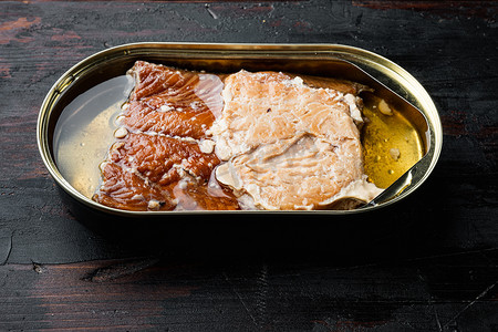 野生阿拉斯加鲑鱼罐头熏鱼，在锡罐中，在旧的深色木桌背景上。