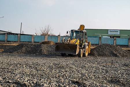 乌克兰，卢茨克 — 2020 年 4 月 10 日：黄色轮式装载机挖掘机在施工现场用砾石作业。