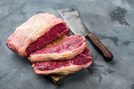 新鲜牛肉切条摄影照片_上腰肉，新鲜有机牛肉切块，灰色背景