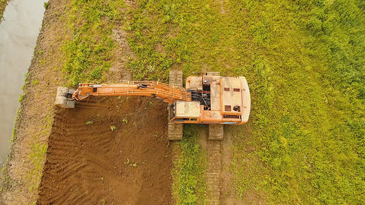 挖掘机在田里挖沟。航拍视频。