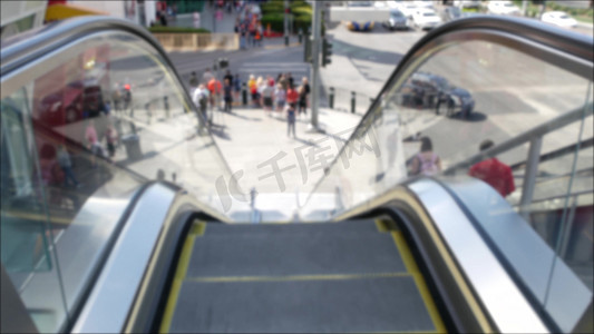 通过自动扶梯的透视图，在美国拉斯维加斯大道的道路交叉口人行横道上散焦的无法辨认的人群。