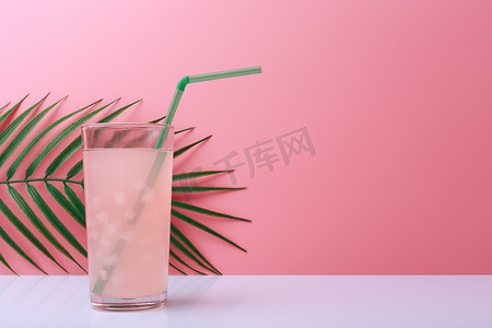 饮料组合摄影照片_创意夏日组合物，粉红色饮料，白桌吸管，亮粉色背景，棕榈叶