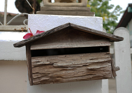 白墙背景上的木制邮箱