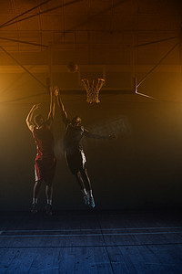 两个篮球运动员：一个投篮，一个跳跃