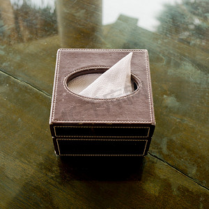 浴室玻璃摄影照片_玻璃桌上的皮革纸巾盒。