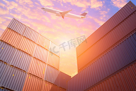 货机飞越堆场中五颜六色的货运集装箱。全球商业集装箱航运、物流、进出口行业的照片概念。