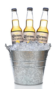 加利福尼亚州欧文市-2018 年 3 月 21 日：冰桶中的三个 Corona Premier 瓶，在带有反射的白色垂直组合物上隔离冷凝