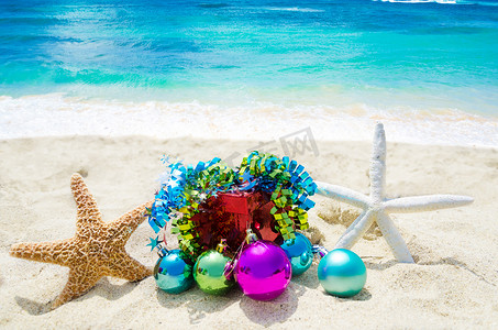 两只海星摄影照片_沙滩上有两只带圣诞球和礼物的海星 — 洒红节