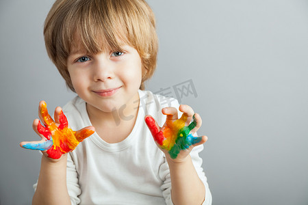 玩颜料的孩子摄影照片_手涂上五颜六色的颜料
