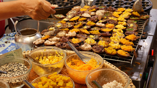 异国情调的东方亚洲甜美甜点，集市柜台上不寻常的色彩缤纷的传统菜肴和街头食品。